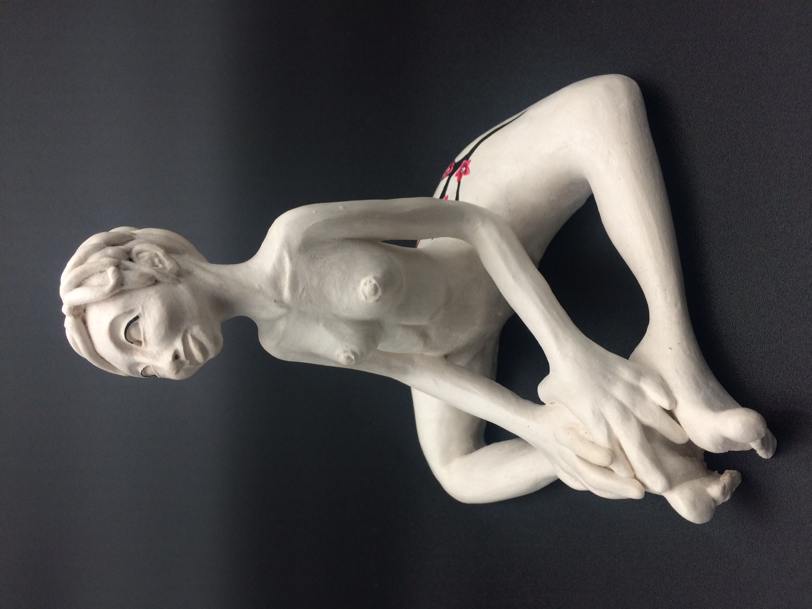 Céramique Femme aux cheveux courts nue et assise avec les jambes en triangle. Les mains reposent sur les pieds.