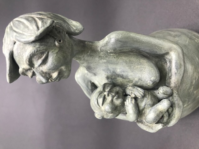 Céramique de femme soutenant un bébé