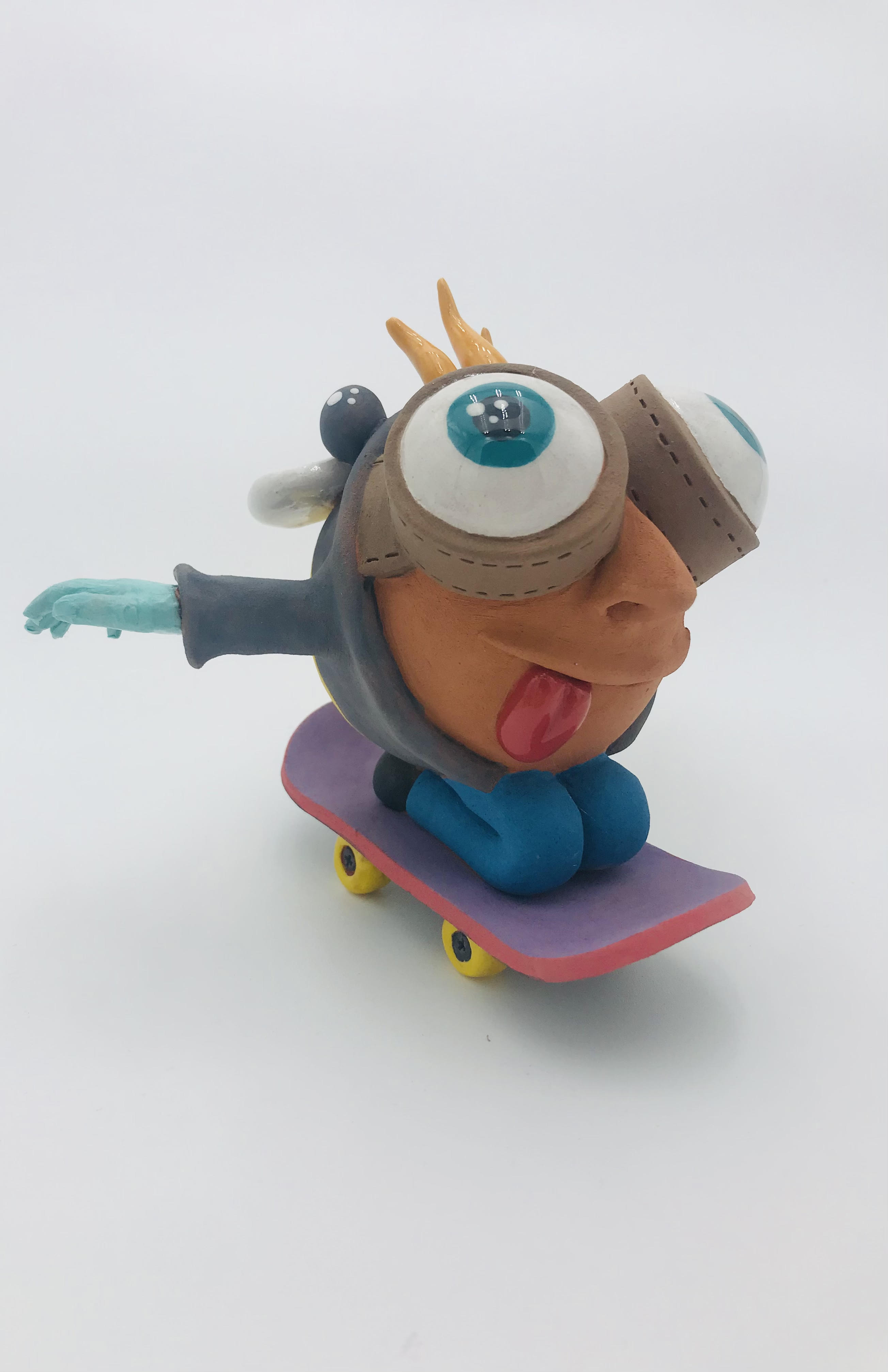 Céramique d'enfant à tête géante sur skate