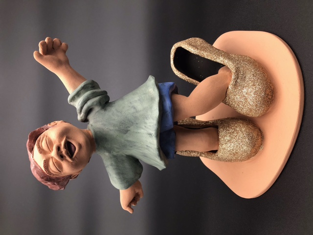 Enfant qui a mis des grandes chaussures à talons.