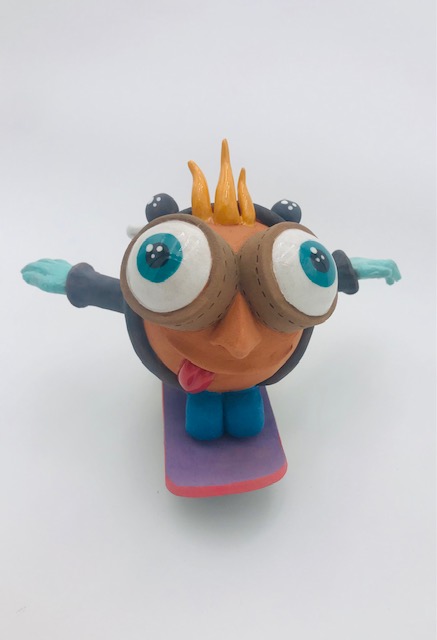 Céramique d'enfant à tête géante à genoux sur skate. Il a des grands yeux et ouvre ses bras.