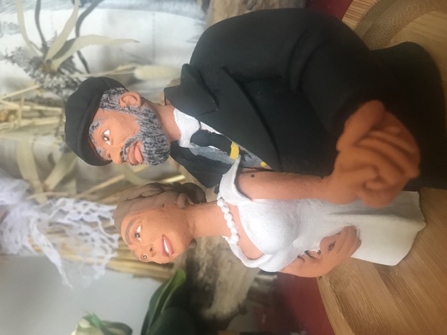 Pièce en céramique qui représente l'image de tête à ceinture d'un couple de mariés, homme et femme. L'homme prend la femme par la taille, ils serrent ses mains.