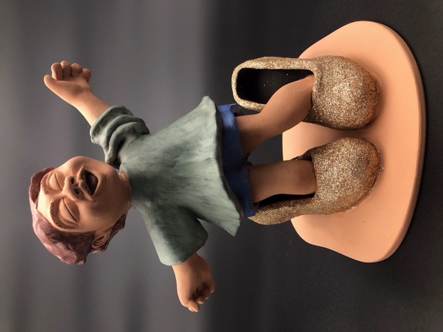 Enfant qui a mis des grandes chaussures à talons.