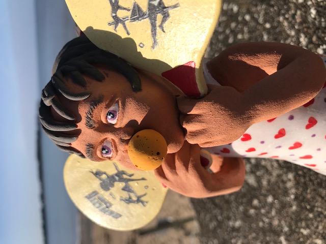 Petite fille avec une balle en mousse dans la bouche et avec raquette dans les mains