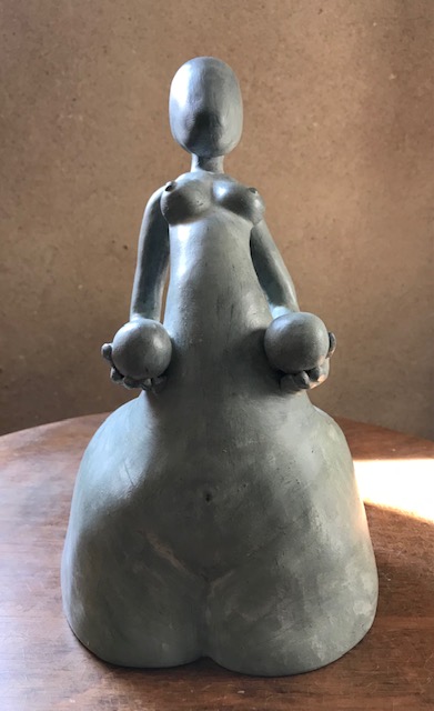 Sculpture de femme en céramique qui soutient deux grands œufs