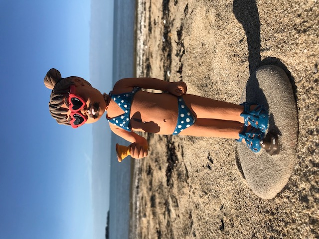 petite fille avec lunettes coeur mangeant une glace sur la plage