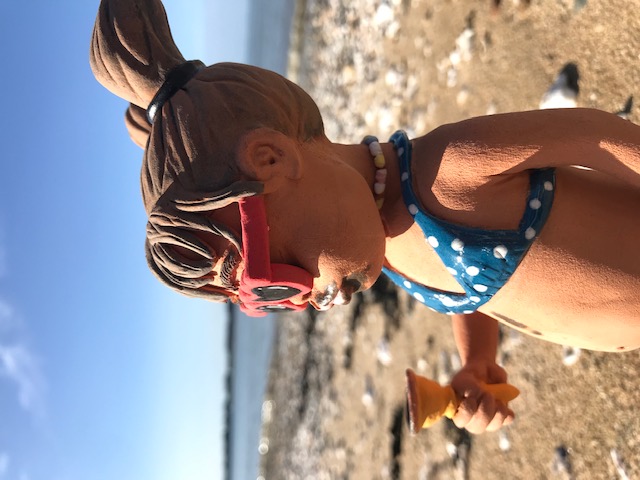 petite fille avec lunettes coeur mangeant une glace sur la plage