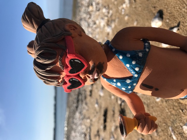 petite fille avec lunettes coeur mangeant une glace sur la plage