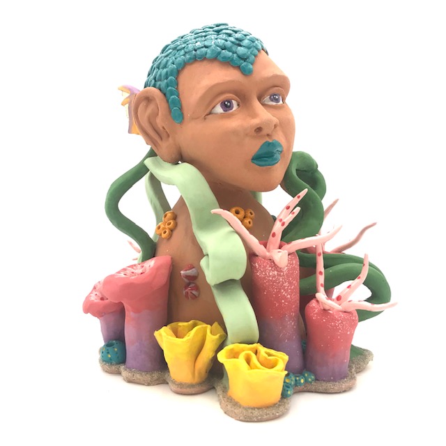 Buste de femme poisson parmis les algues très colorées