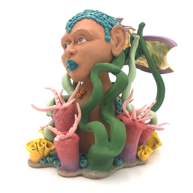 Buste de femme poisson parmis les algues très colorées