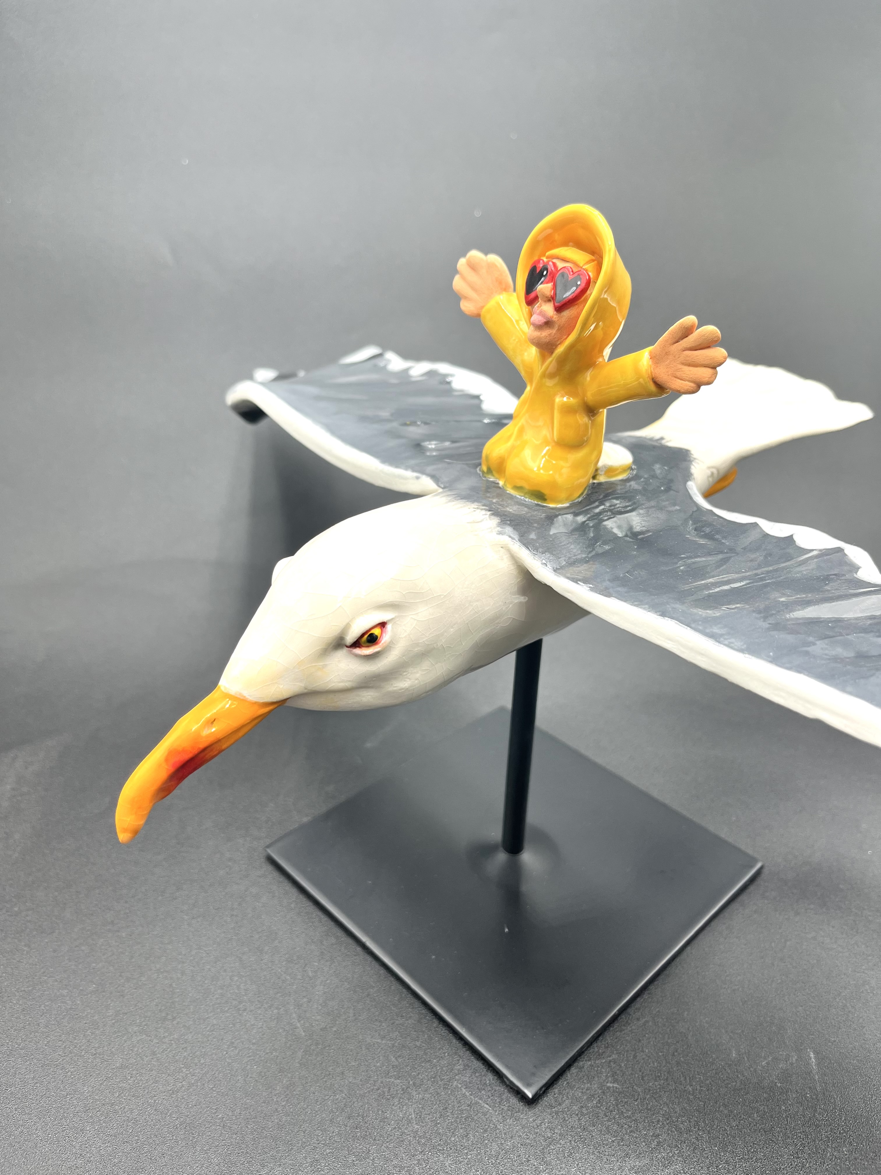 Sculpture céramique d'un petit personnage en ciré chevauchant un goéland