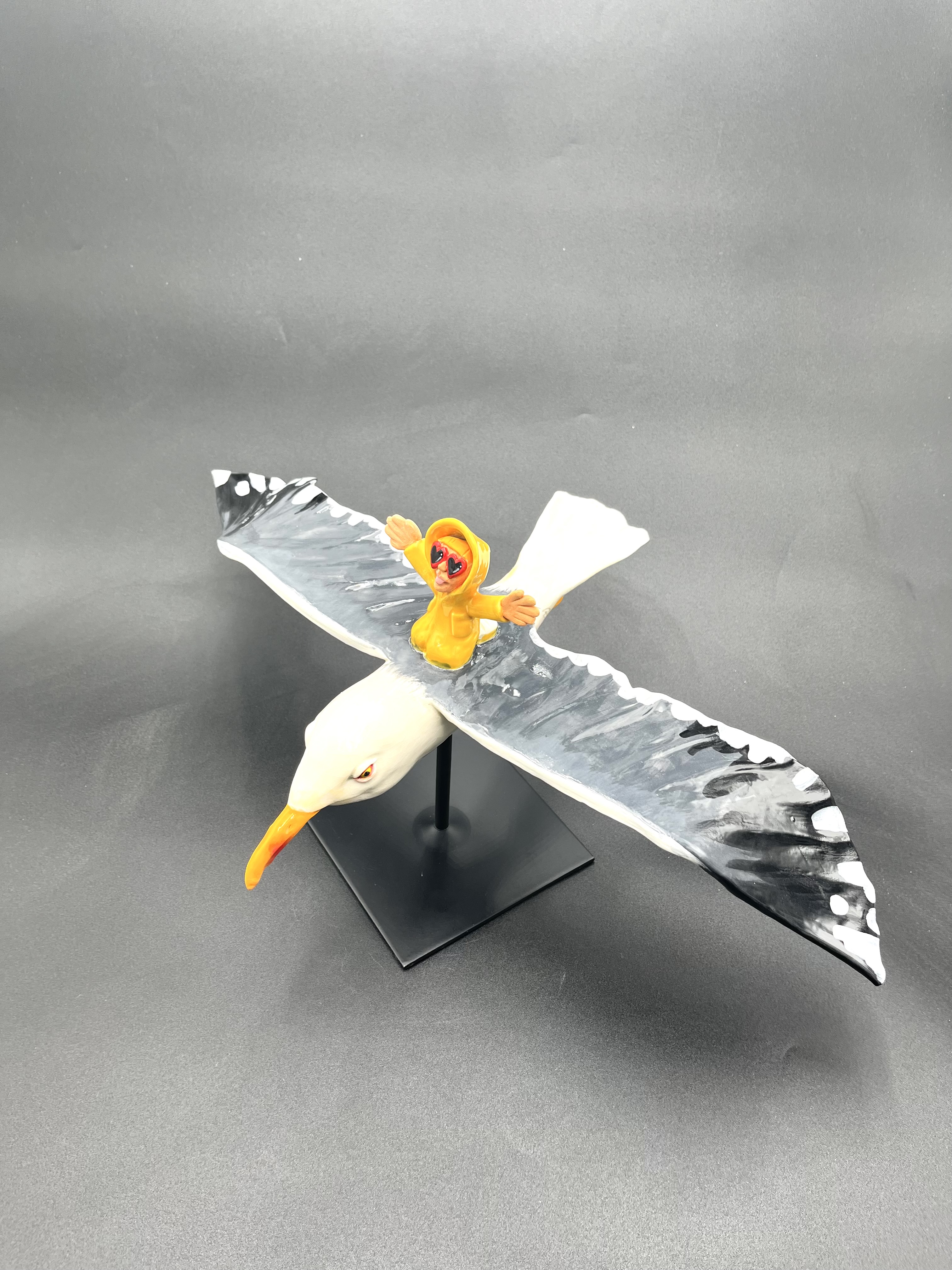 Sculpture céramique d'un petit personnage en ciré chevauchant un goéland